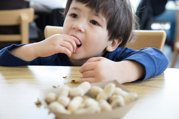 boy picking from a plate of peanuts