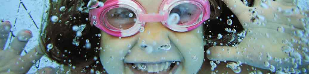 Girl in the water wearing pink goggles