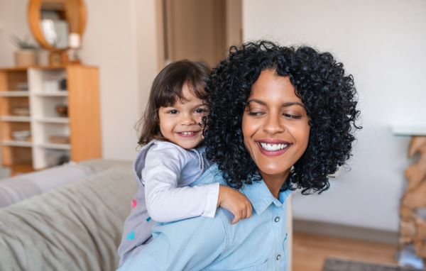 mother carrying daughter on her back