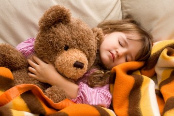 Young girl sleeping with her teddy bear