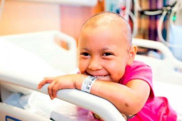 Smiling cancer patient on hospital bed