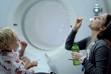 Child life specialist blowing bubbles for patient