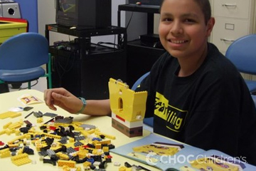 Boy patient playing with Legos at a table