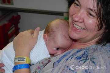 Smiling mo with baby in the NICU