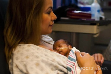 Mother holding premature baby in the NICU