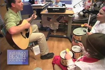 Eric Mammen playing guitar for patients