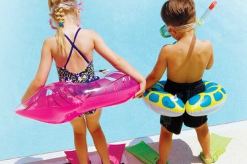 Girl and boy at the pool with their water toys