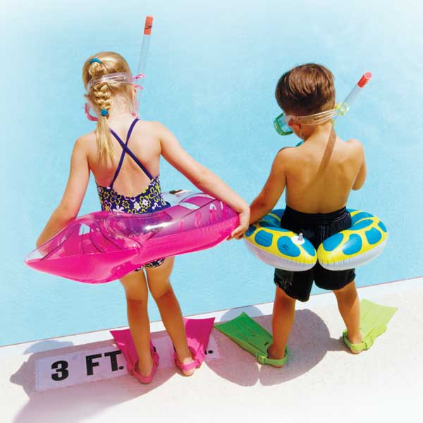 Girl and boy at the pool with their water toys