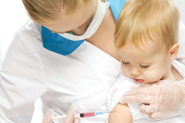 Clinician giving young child vaccination shot 