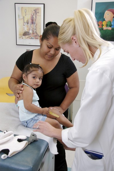 Physician with mom and child in exam room