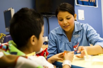 Volunteer with patient in playroom