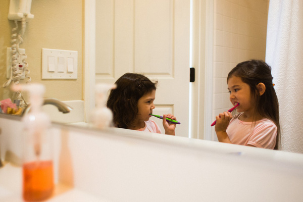 Two young girls brushing their teeth in the bathroom
