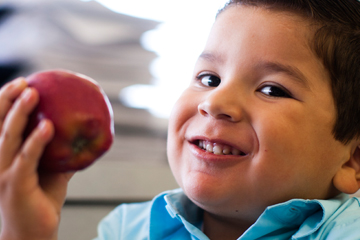 Young boy eating an apple