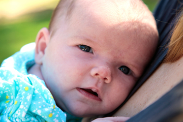 Close-up of infant being held by mom