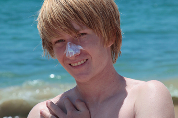 Teen boy at the beach with sunscreen on his nose