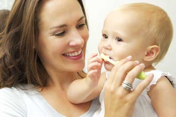 Mom brushing the teeth of her young child