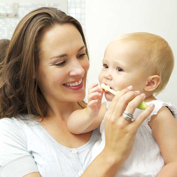 Mom brushing the teeth of her young child