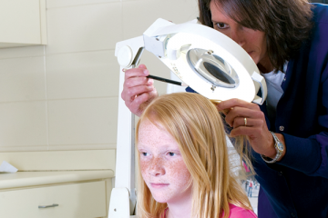 Nurse examining head of your girl for lice