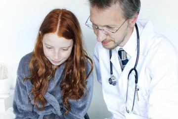 Physician showing young girl information on his ipad