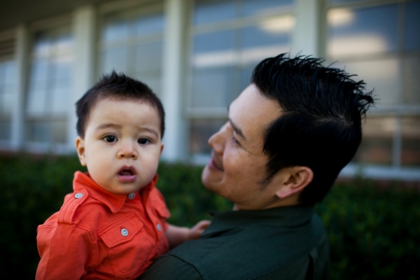 Father holding and smiling at his young son