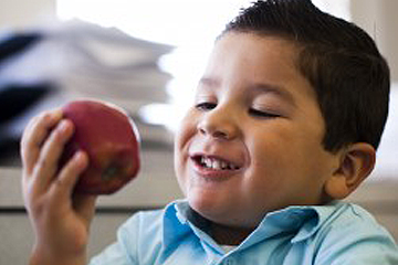 Young boy eating an apple