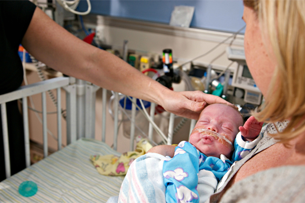 Mom holding her preemie infant in the NICU