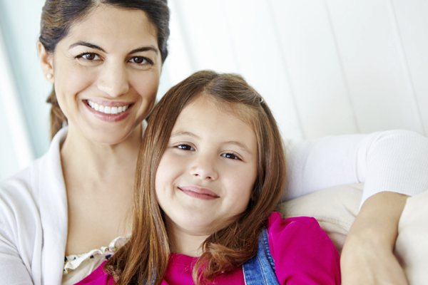 Mom with daughter smiling at the camera