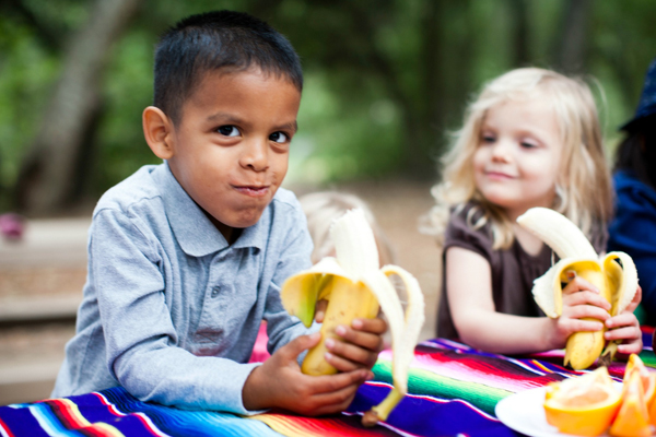 Boy and girl eating bananas