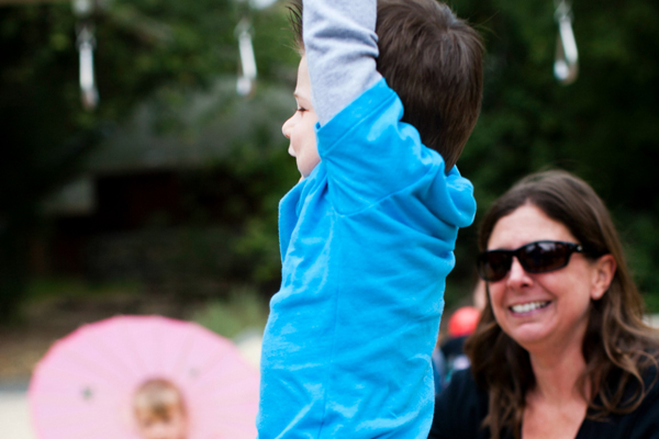 Mom watching young son with his arms in the air