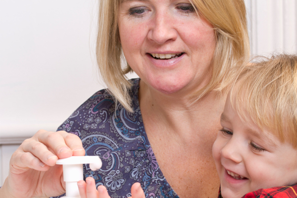 Mom helping son sanitize his hands