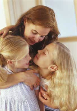 Mom with arms around her two daughters