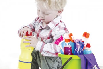 Toddler boy trying to open bottle with cleaner fluid