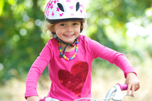 Girl on bicycle wearing a helmet