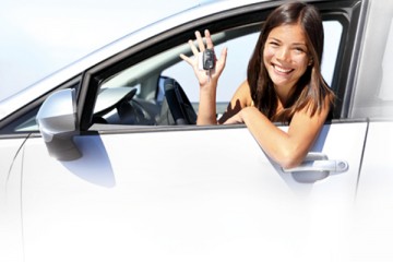 Smiling teen girl in driver's seat holding car keys