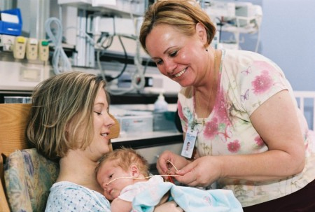 Nurse with mom and infant in the NICU
