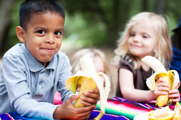 Boy and girl eating bananas