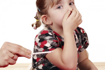 Little girl holding her nose with lighted cigarette near