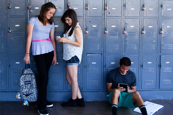 Teens in school hallway by lockers
