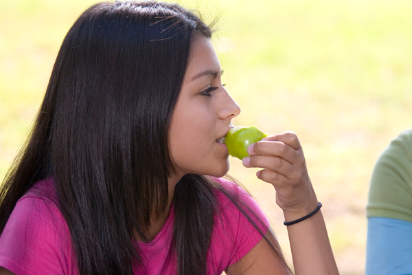 Teen girl eating an apple