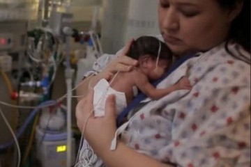 Mom holding infant in the NICU