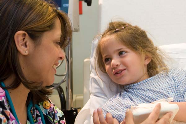 Nurse smiling at young girl patient
