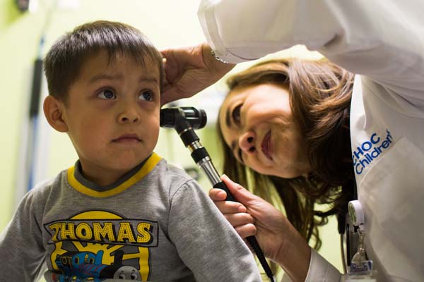 Pediatrician giving small boy health exam
