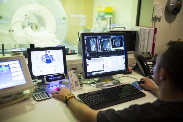 Technician looking at monitors with MRI images