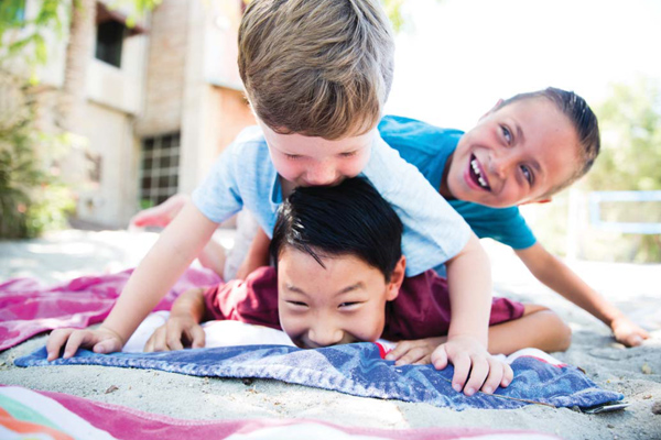 Three boys playing on the ground