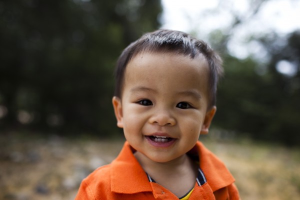 Happy toddler boy close-up in orange shirt