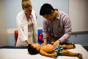 Gastroenterology team giving young child physical exam