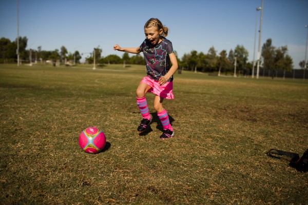Girl playing with soccer ball on the field