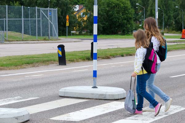 Children with backpacks walking across the street