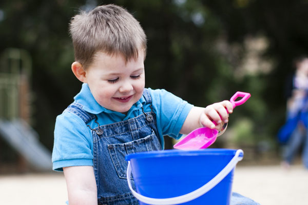 Boy shoveling sand