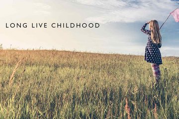 Girl looking out over a field and holding flag